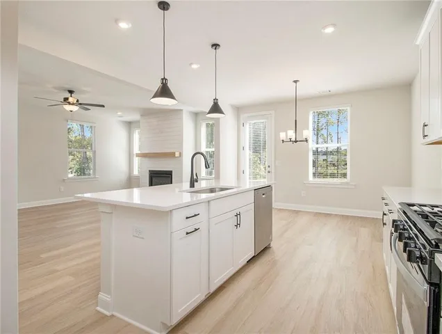 a kitchen with stainless steel appliances granite countertop a sink stove and wooden floor