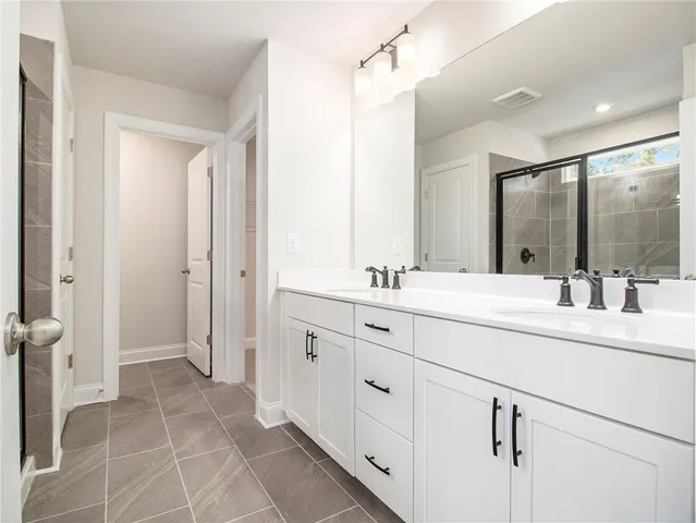 a spacious bathroom with double sink and a mirror