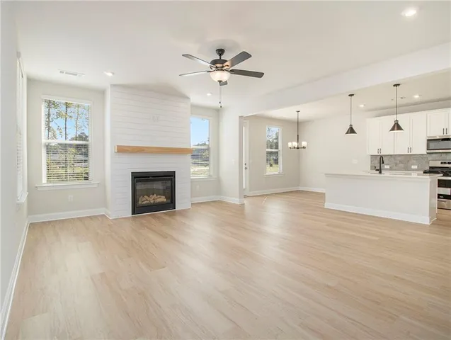 a view of an empty room with a fireplace and window