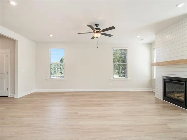 an empty room with windows and fireplace