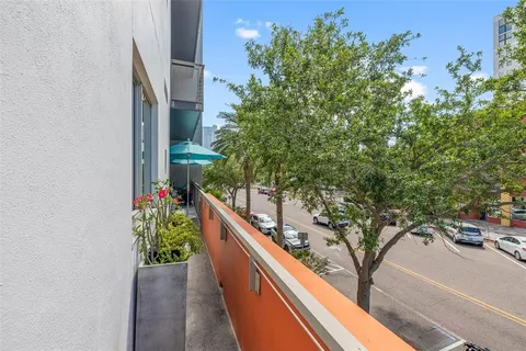 a view of a patio with couches table and chairs under an umbrella