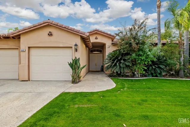 a view of a house with a yard and a garage