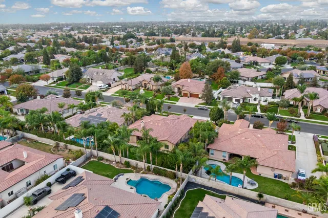 an aerial view of residential houses with outdoor space and parking