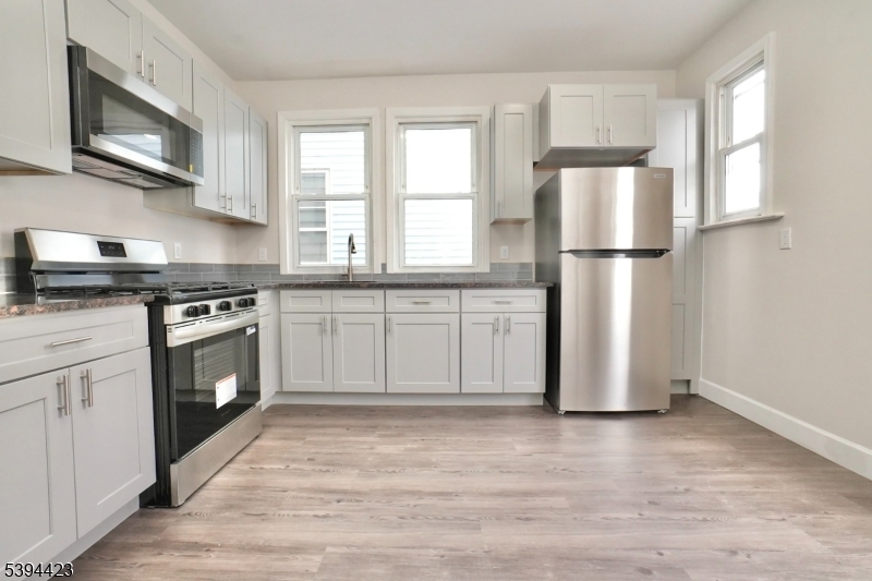 282 Woodside Avenue, Unit 1 Newark, NJ 07104 - Photo 2 of 18 a kitchen with a stove top oven a refrigerator and cabinets
