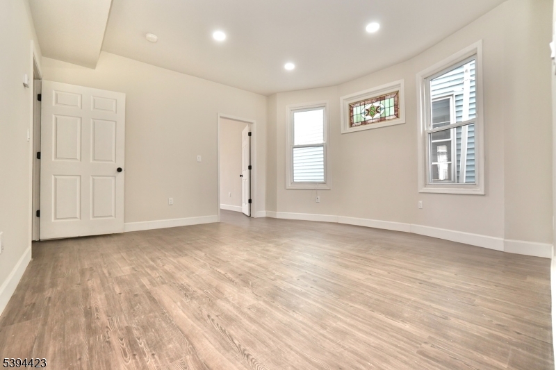 282 Woodside Avenue, Unit 1 Newark, NJ 07104 - Photo 7 of 18 a view of empty room with wooden floor and fan