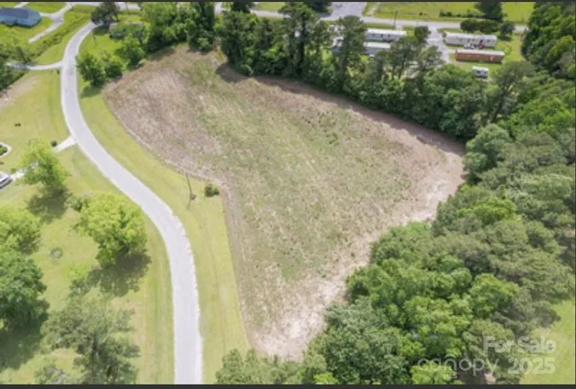 a view of a swimming pool with a yard and large trees