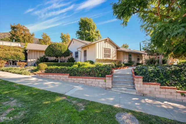 a front view of a house with a garden