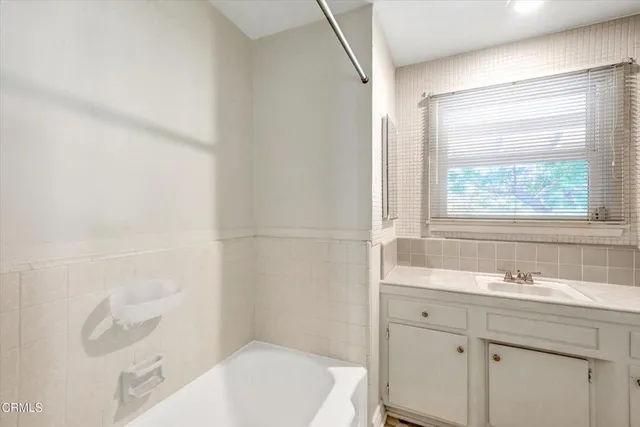 an empty room with a window and ceiling fan