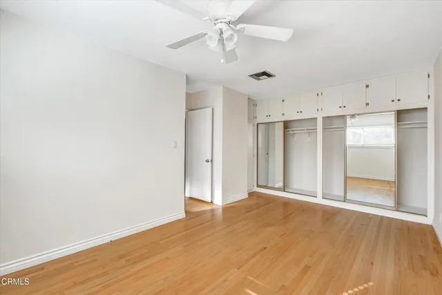 a view of a hallway with wooden floor and closet