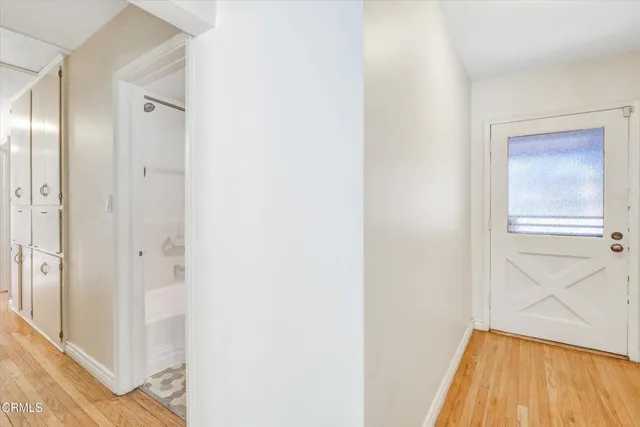 an empty room with wooden floor fireplace and windows