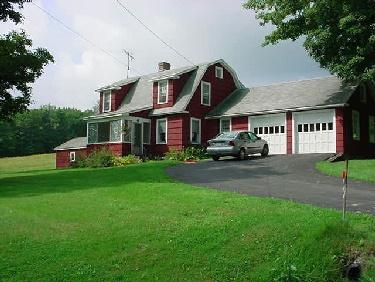 a front view of a house with a garden and plants