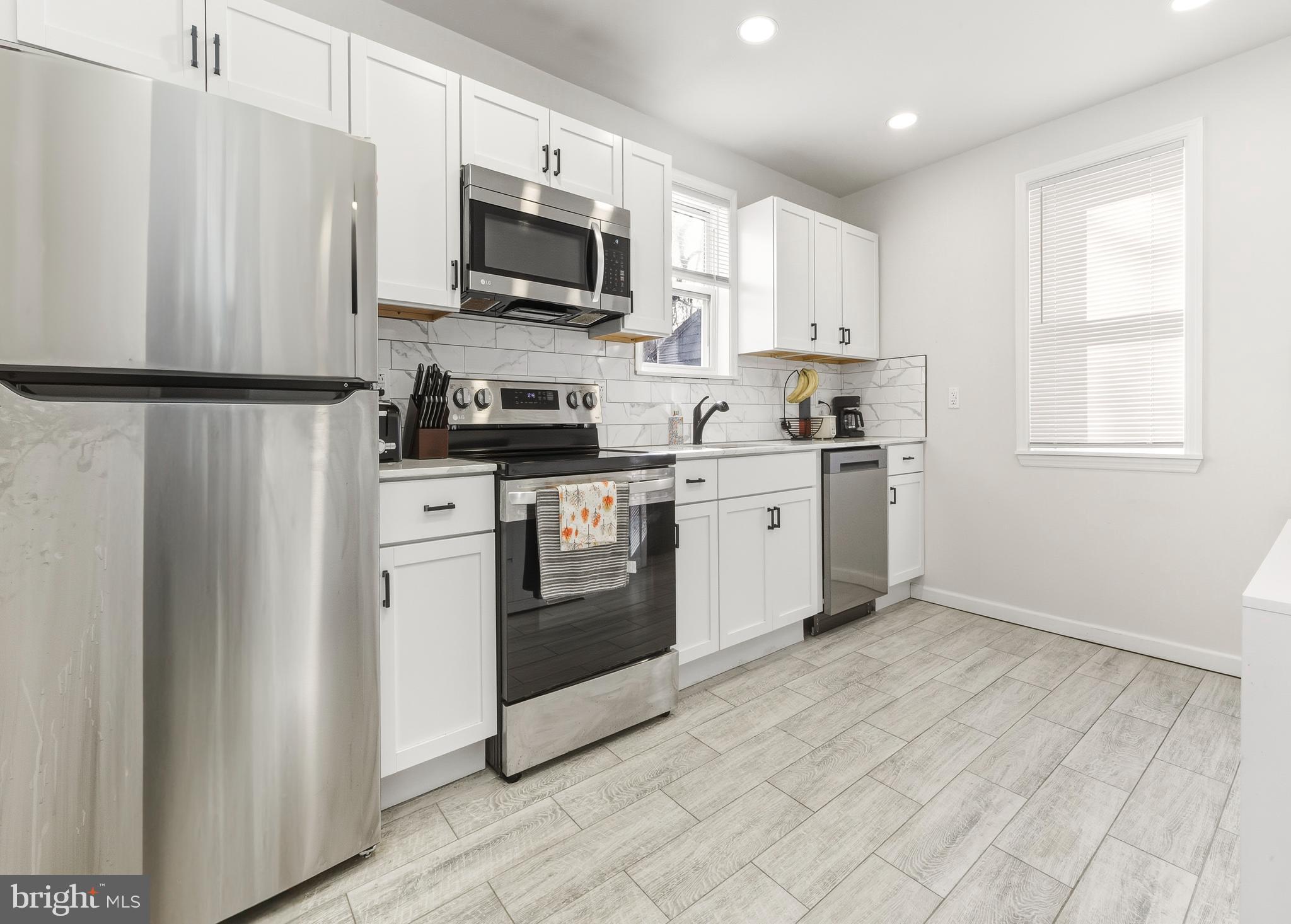 1287 Clements Bridge Road Woodbury, NJ 08096 - Photo 6 of 16 a kitchen with stainless steel appliances granite countertop a stove a sink and a refrigerator