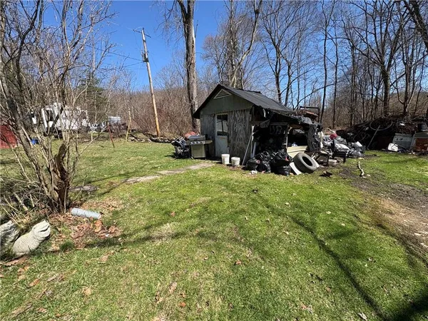 a view of a house with backyard and trees