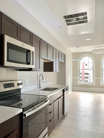 a kitchen with stainless steel appliances a stove microwave and sink