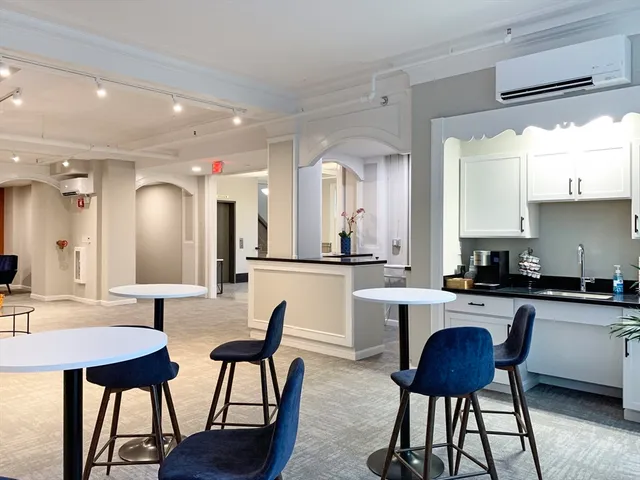 a kitchen with a dining table chairs and sink