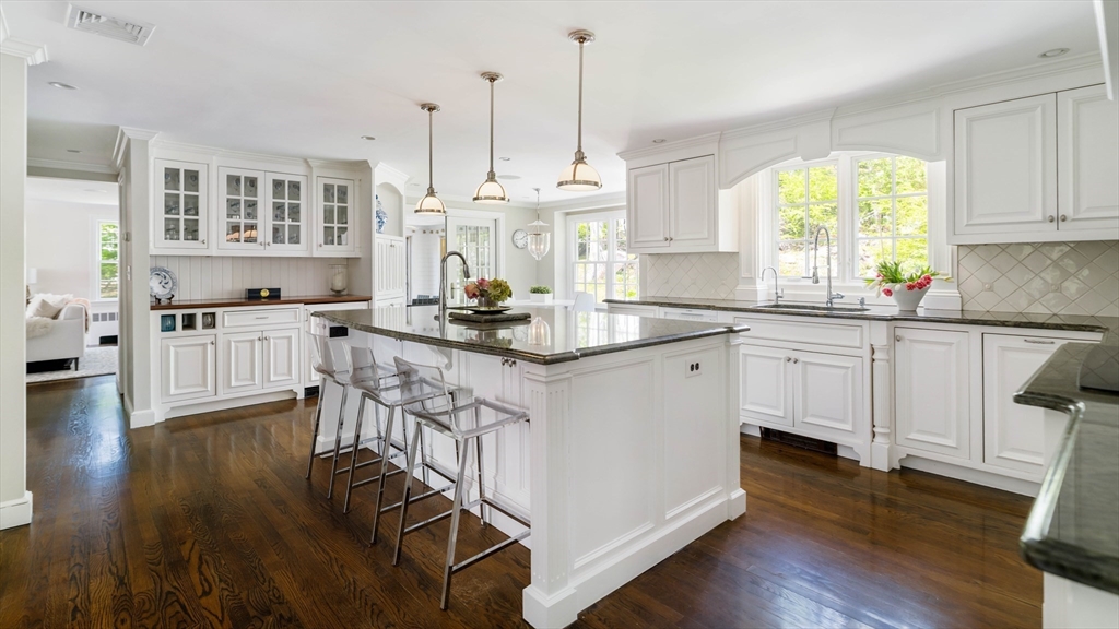 81 Hampshire Road Wellesley, MA 02481 - Photo 6 of 28 a kitchen with stainless steel appliances granite countertop a stove a sink dishwasher a refrigerator white cabinets and wooden floor next to a window