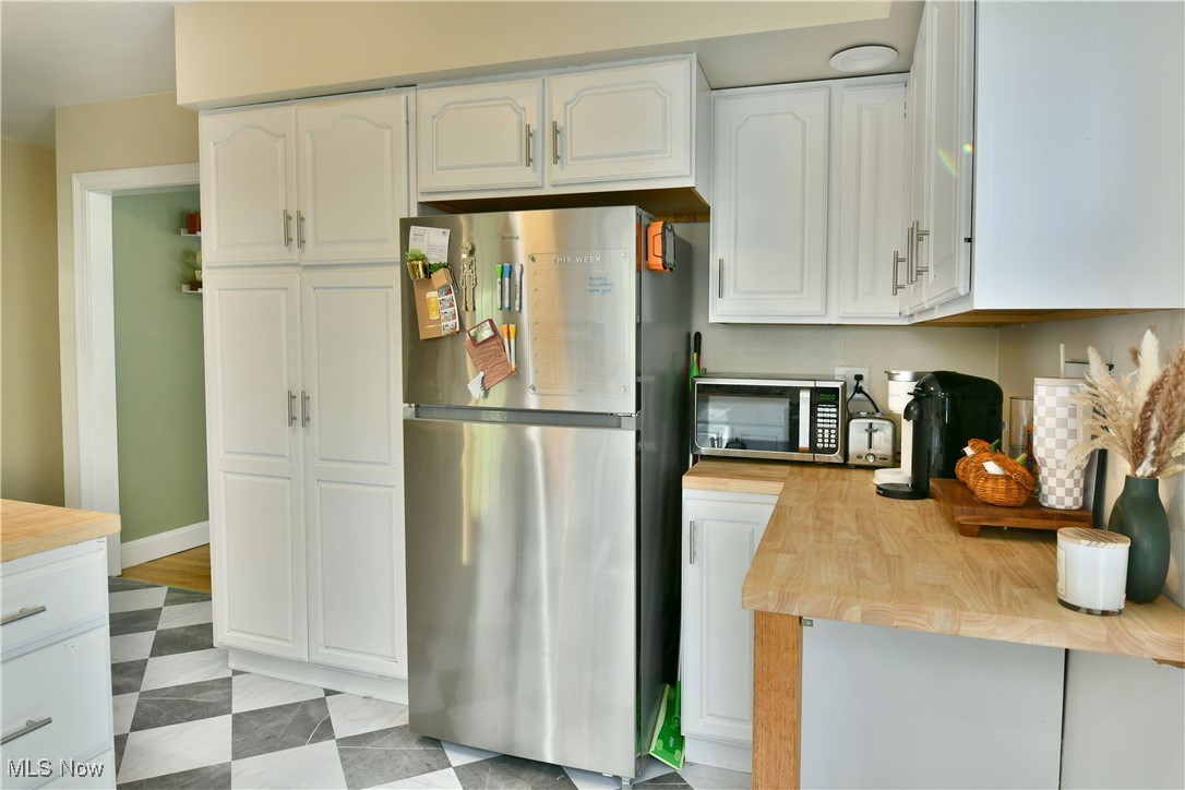 572 Howland Wilson Road Southeast Warren, OH 44484 - Photo 12 of 50 Kitchen with white cabinets, stainless steel appliances, and wood counters