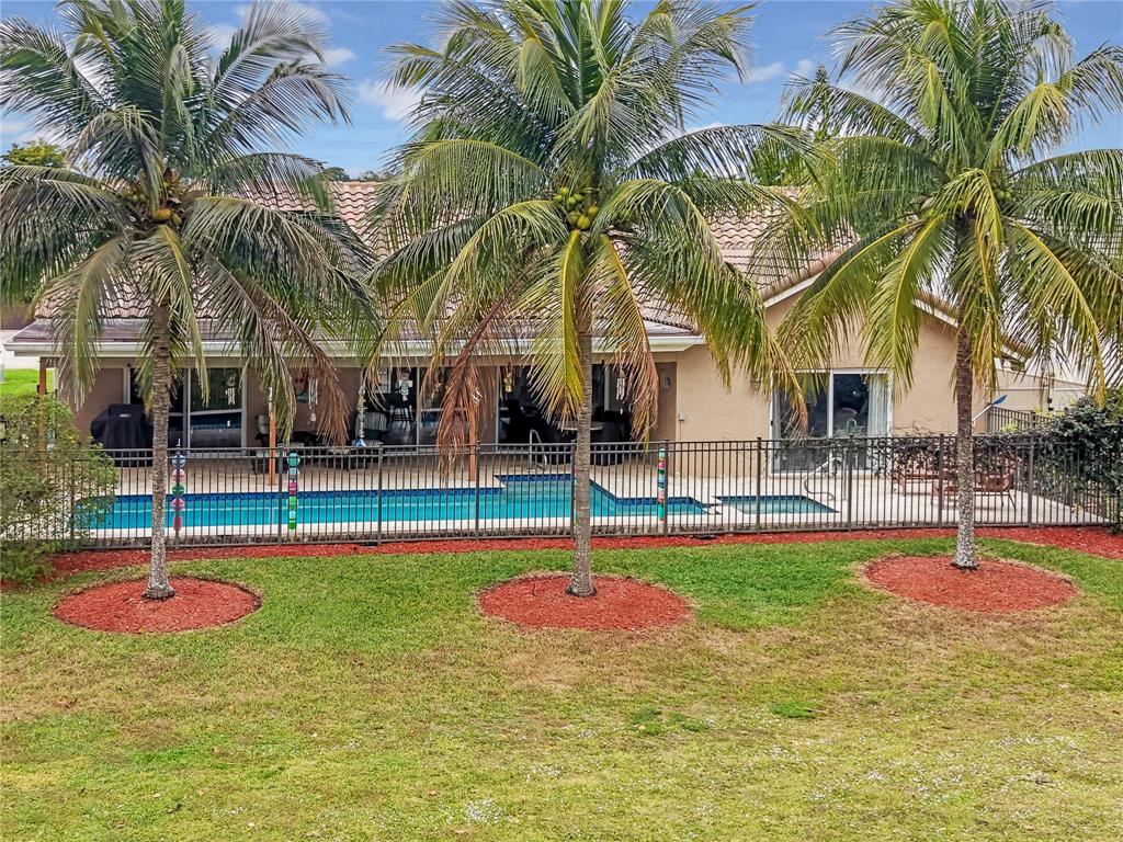 8324 Northwest 80th Street Tamarac, FL 33321 - Photo 37 of 40 a view of a swimming pool with a table and chairs