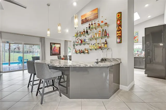 a view of swimming pool with lawn chairs and palm trees