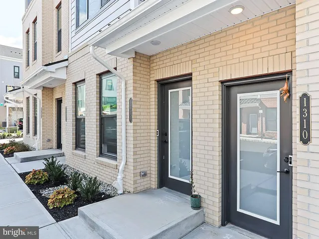 a view of a brick house with potted plants