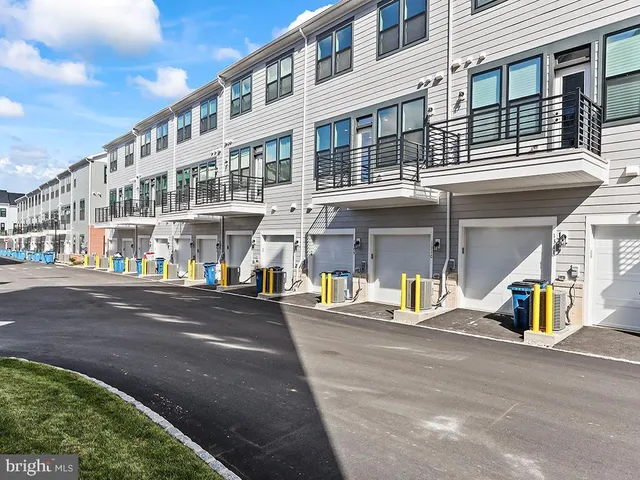 a front view of a building with lot of cars and trees