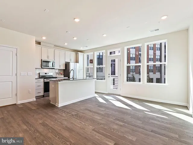 a view of kitchen with granite countertop stainless steel appliances refrigerator sink and cabinets