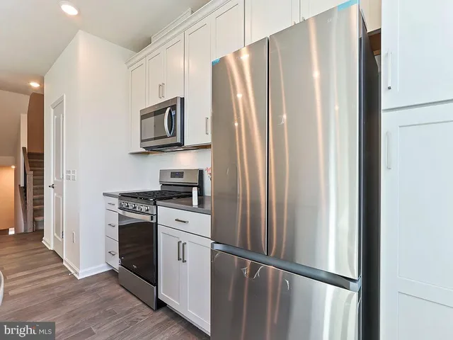 a kitchen with stainless steel appliances a refrigerator sink and microwave