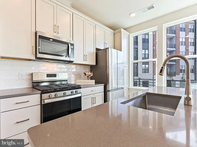 a kitchen with stainless steel appliances granite countertop a stove refrigerator sink and cabinets