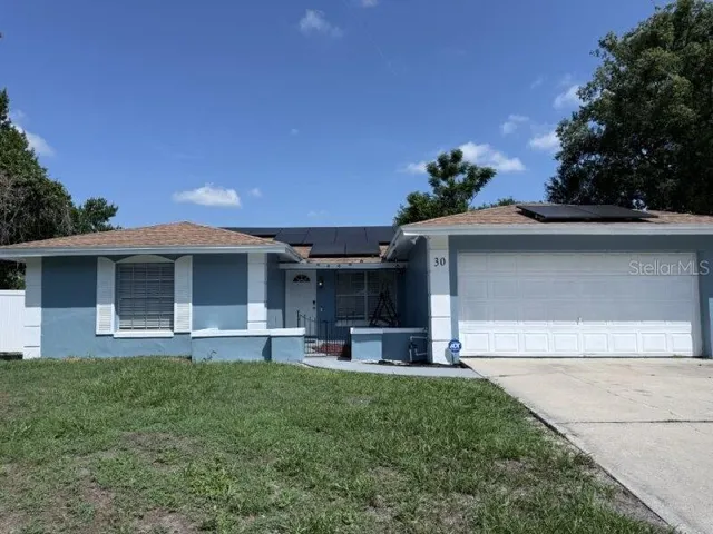 a front view of a house with a garden and yard
