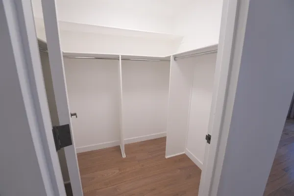 a view of walk in closet with clothes and shoes
