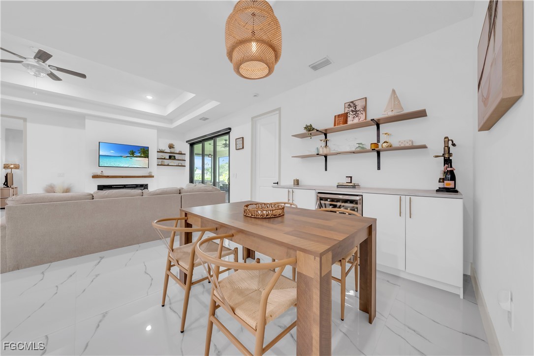 2609 27th Street West Lehigh Acres, FL 33971 - Photo 11 of 35 a kitchen with stainless steel appliances granite countertop a stove top oven a sink a dining table and chairs with wooden floor