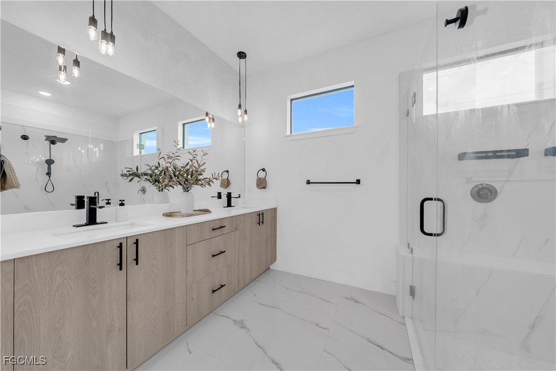 2609 27th Street West Lehigh Acres, FL 33971 - Photo 17 of 35 a large white bathroom with a double vanity sink a mirror and shower