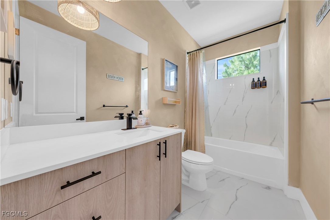 2609 27th Street West Lehigh Acres, FL 33971 - Photo 21 of 35 a bathroom with a sink a toilet and shower