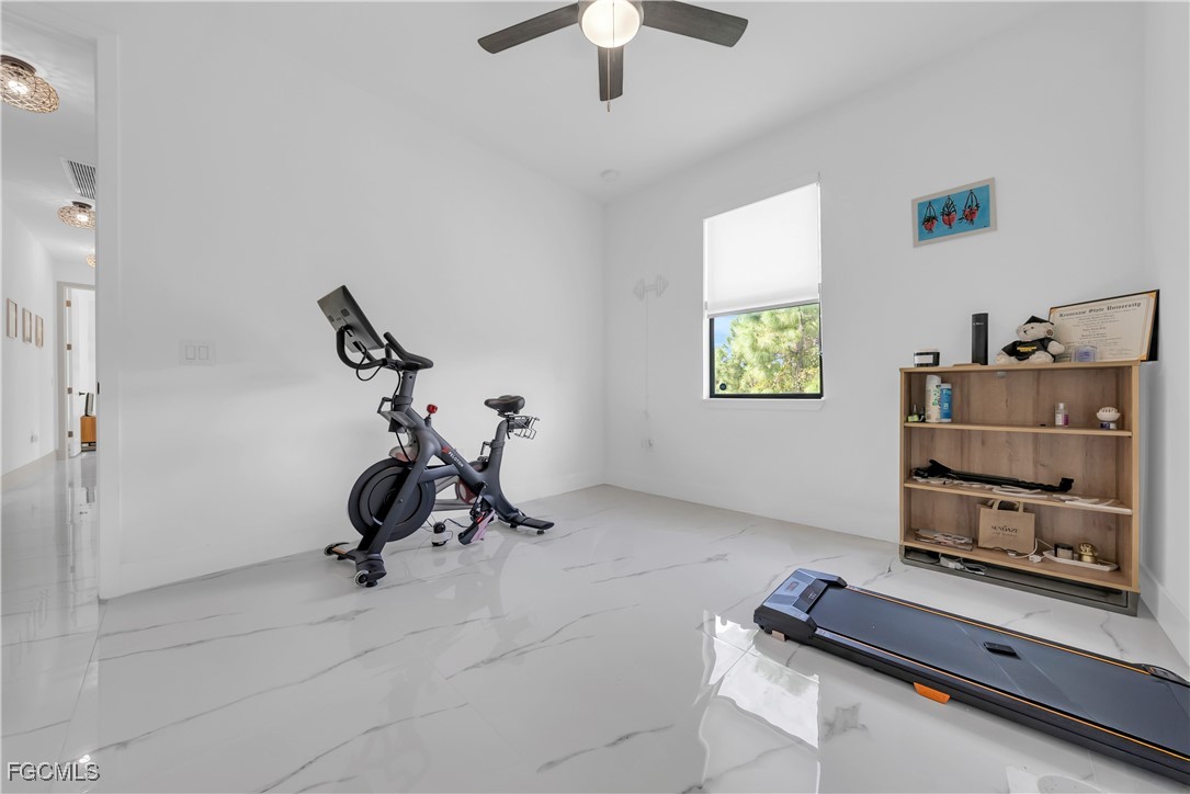 2609 27th Street West Lehigh Acres, FL 33971 - Photo 22 of 35 a room with gym equipment and a flat screen tv