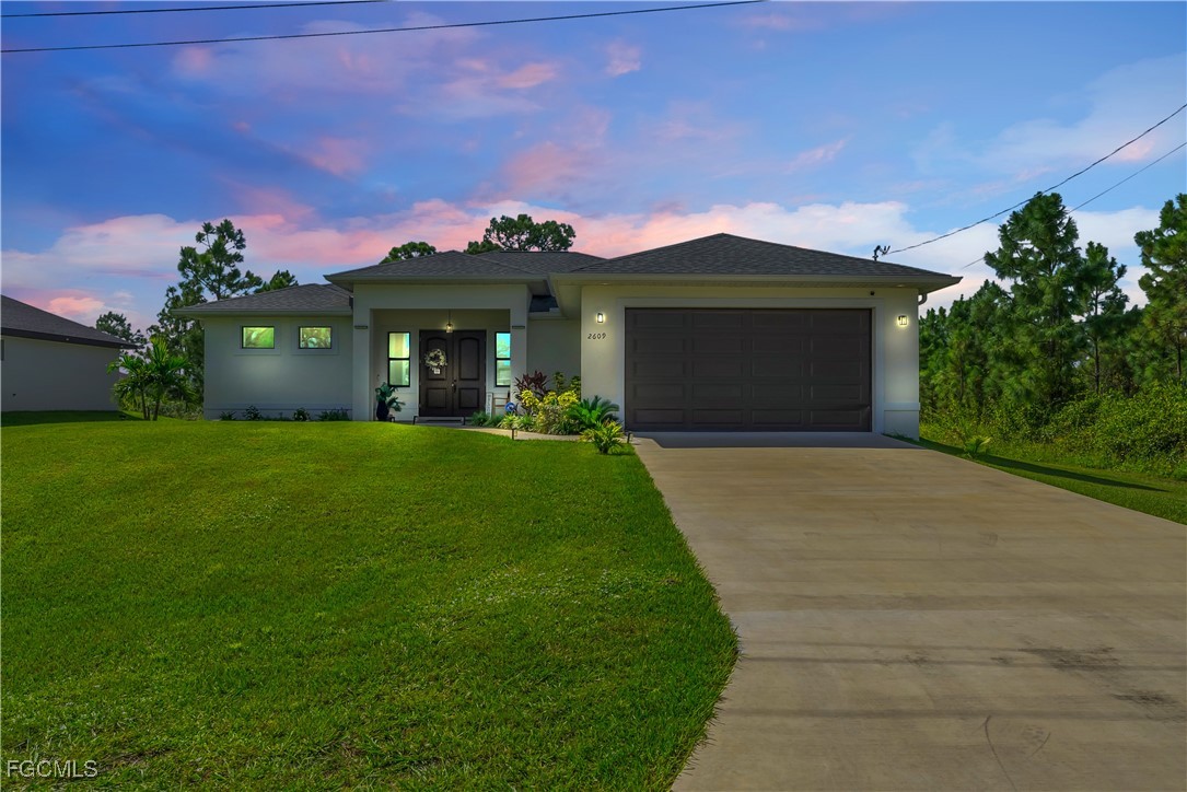 2609 27th Street West Lehigh Acres, FL 33971 - Photo 35 of 35 a front view of a house with a yard and garage