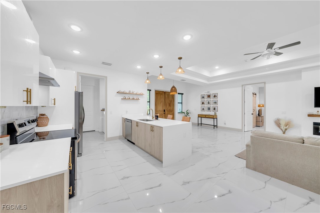 2609 27th Street West Lehigh Acres, FL 33971 - Photo 7 of 35 a large white kitchen with a large counter top appliances and cabinets