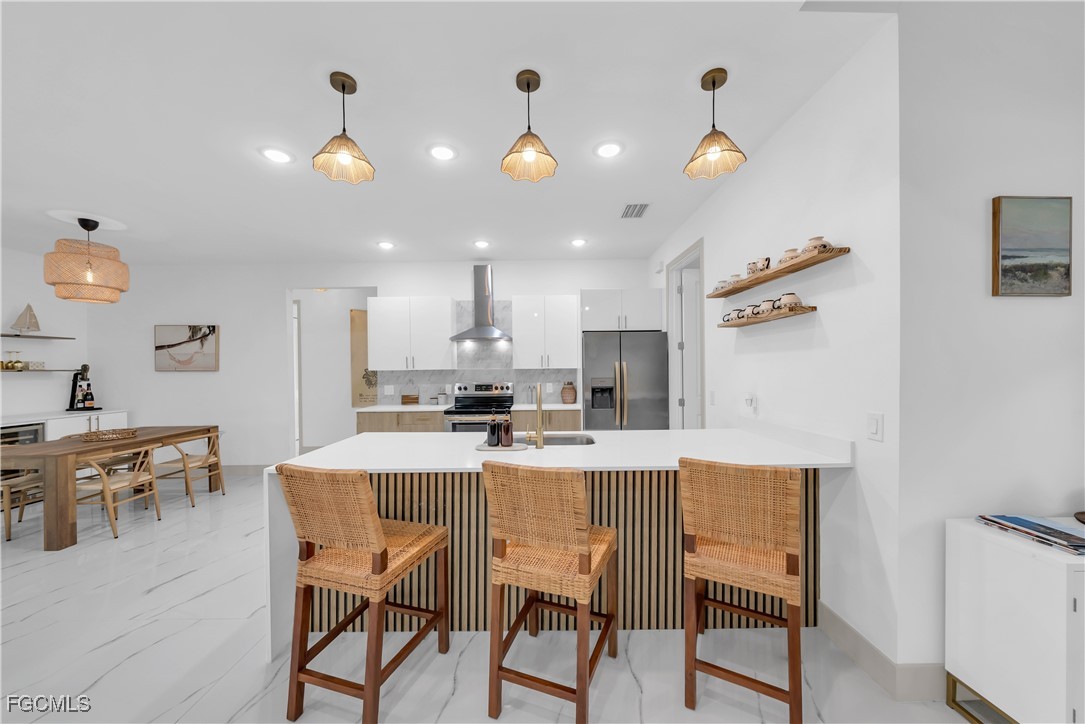 2609 27th Street West Lehigh Acres, FL 33971 - Photo 10 of 35 a kitchen with kitchen island a dining table and chairs