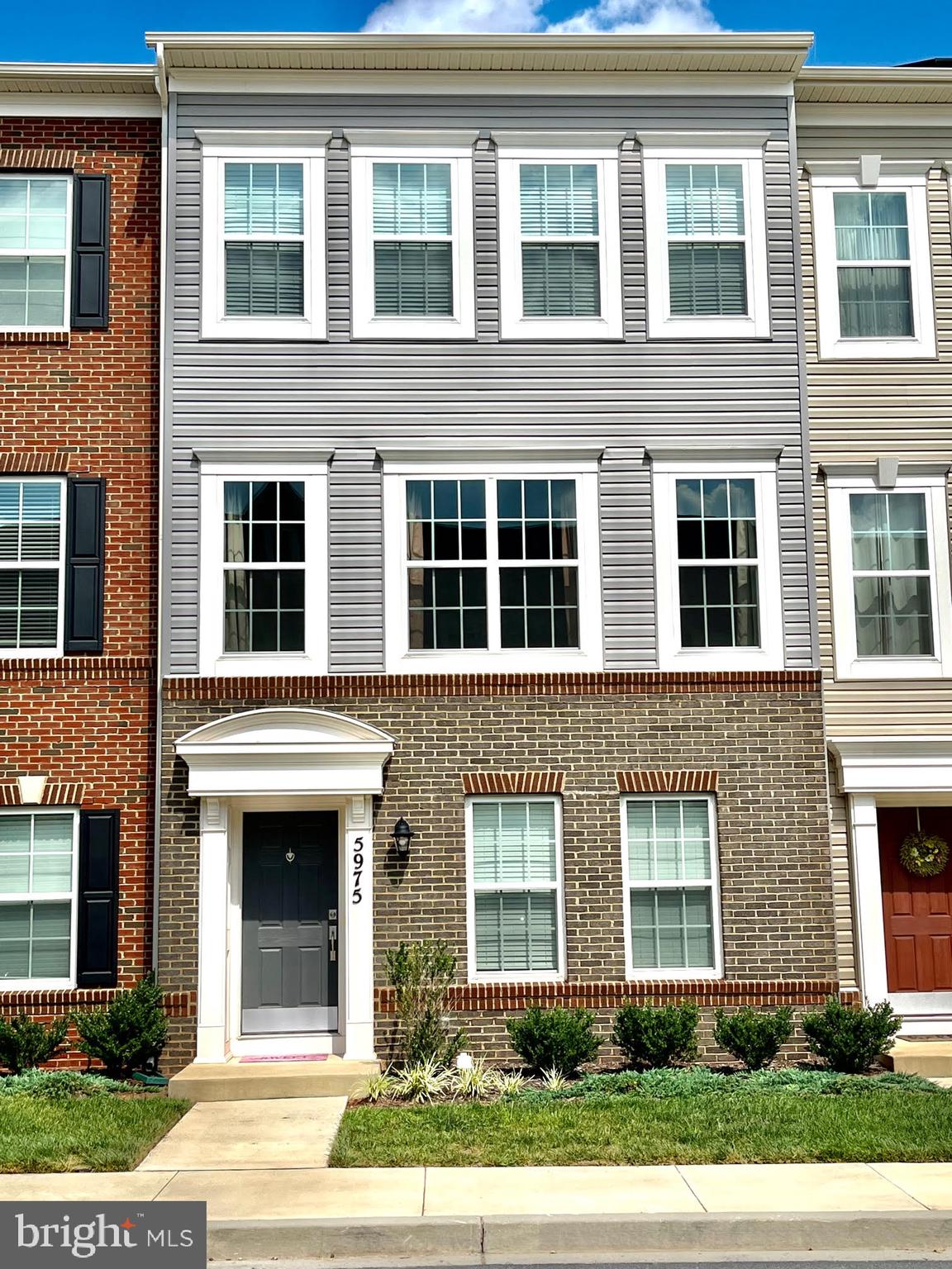 a front view of a building with a garden
