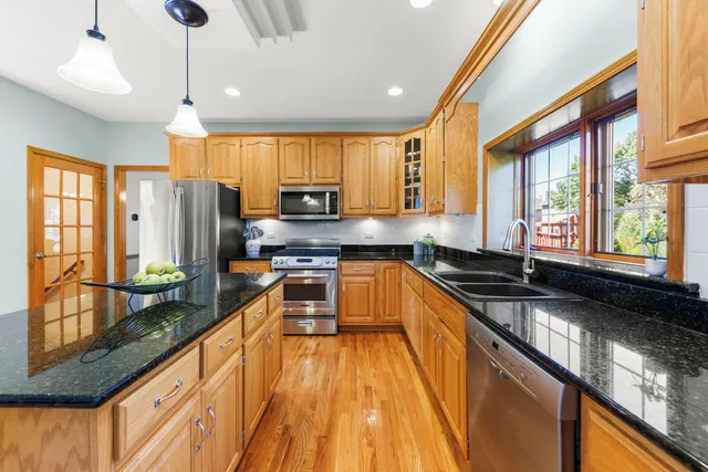 a large kitchen with stainless steel appliances a large window and counter space