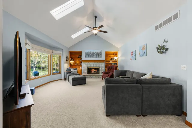 a living room with furniture a flat screen tv and a fireplace