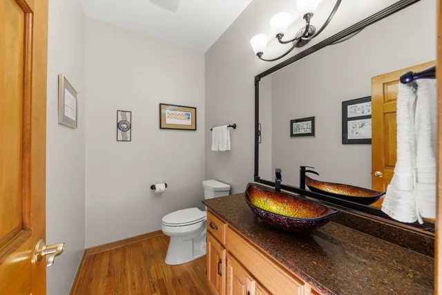 a bathroom with a granite countertop toilet sink and mirror