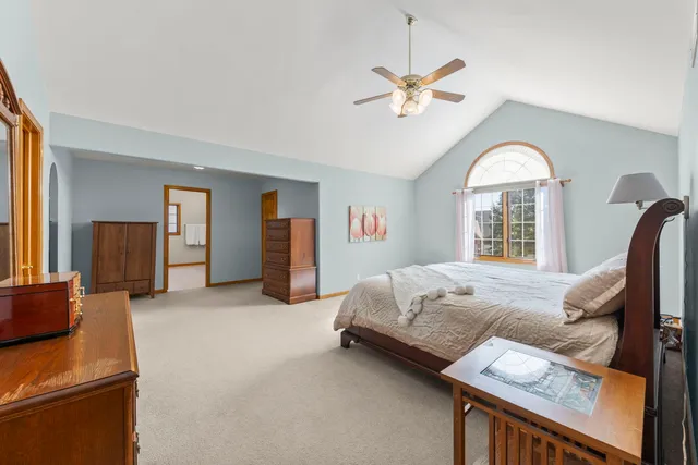 a spacious bedroom with a bed and a chandelier