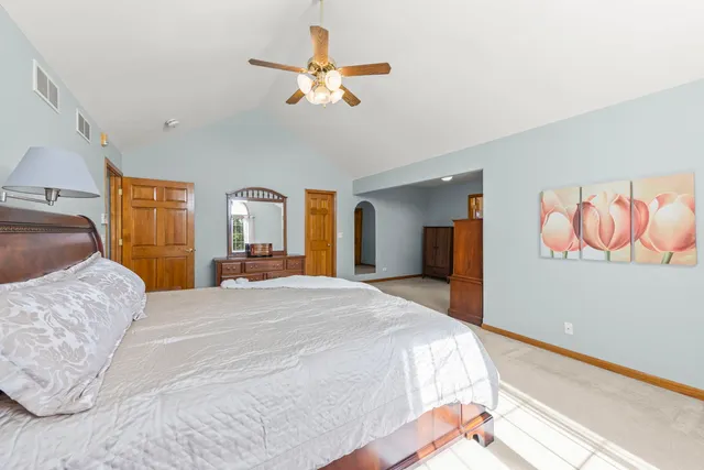 a bedroom with a large bed and a chandelier