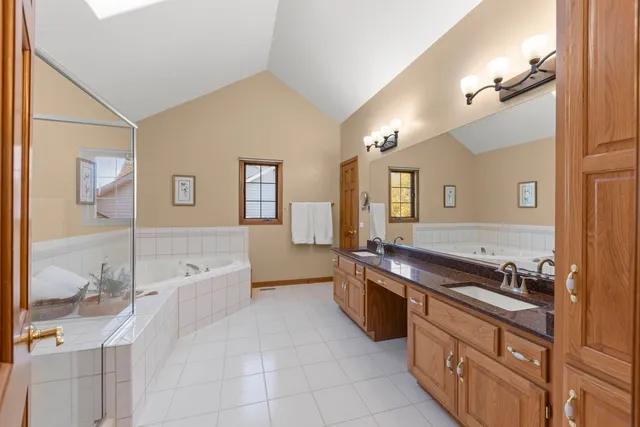a spacious bathroom with a granite countertop tub sink and mirror