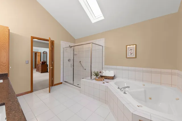 a bathroom with a tub a sink and mirror