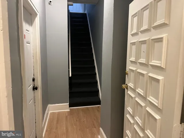 a view of a hallway with wooden floor and entryway