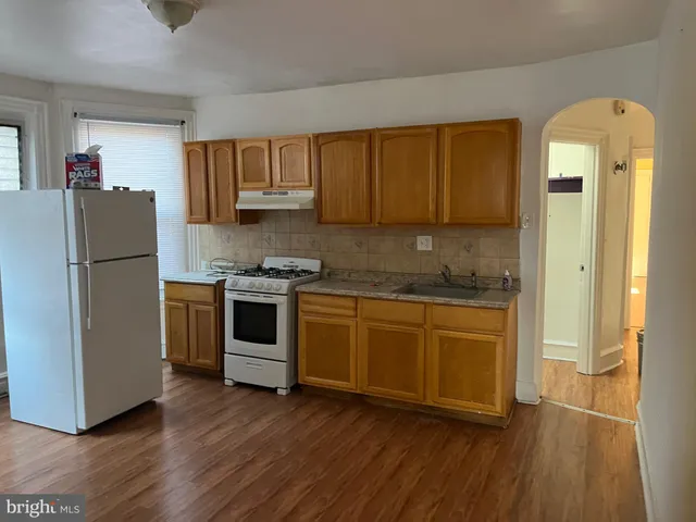 a kitchen with granite countertop a refrigerator and a stove top oven