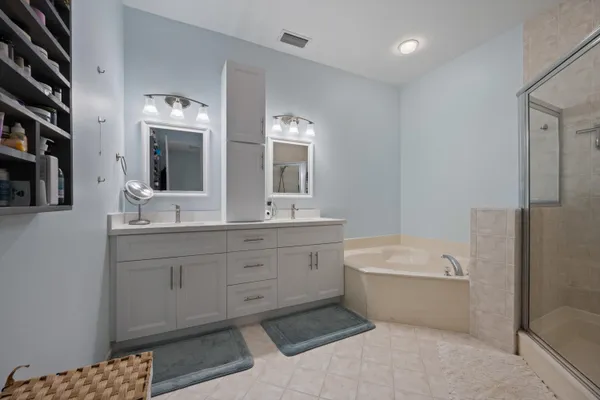 a spacious bathroom with a double vanity sink a mirror and a bathtub