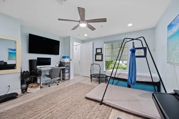 a living room with furniture a flat screen tv and a floor to ceiling window