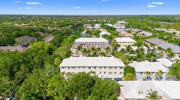 an aerial view of residential houses with outdoor space and trees